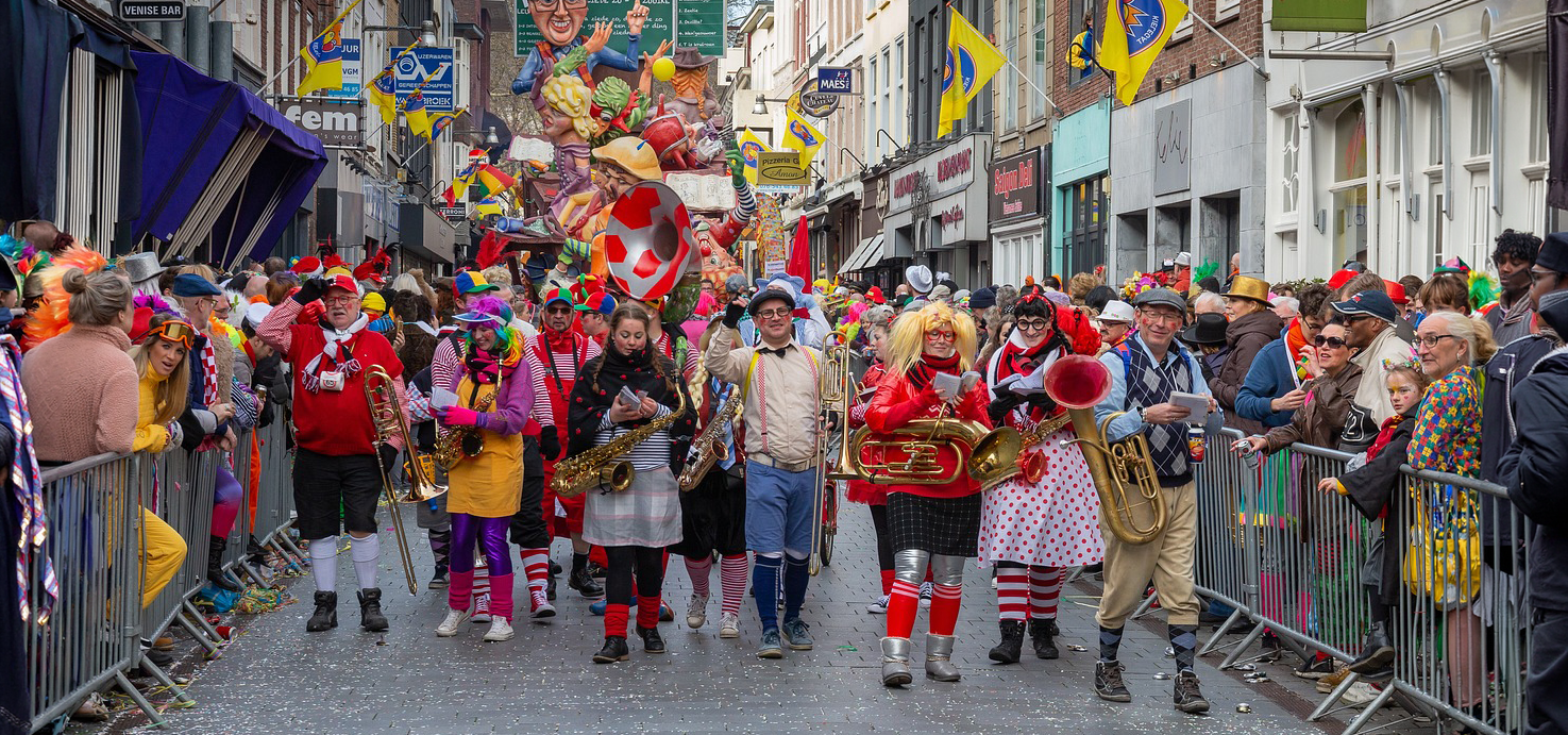 Foto van straat met carnavalsoptocht en publiek